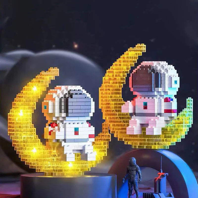 Zwei aus Klemmbausteinen zusammengebaute Nachtlichter in der Form von Astronauten, die auf Halbmonden sitzen. Ein Nachtlicht ist eingeschaltet, das andere nicht.